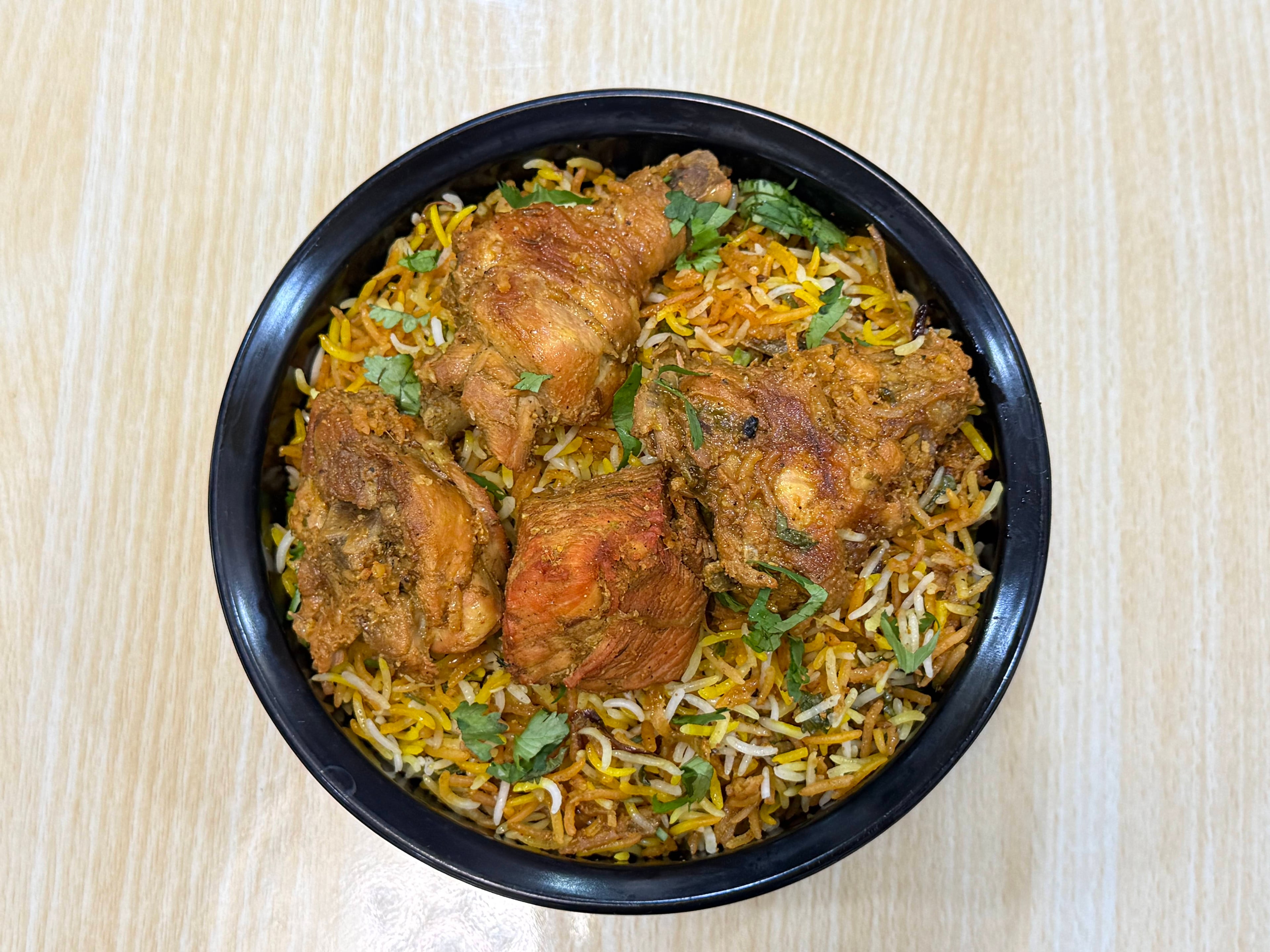 Hyderabadi Chicken Biryani with garnishes and sides